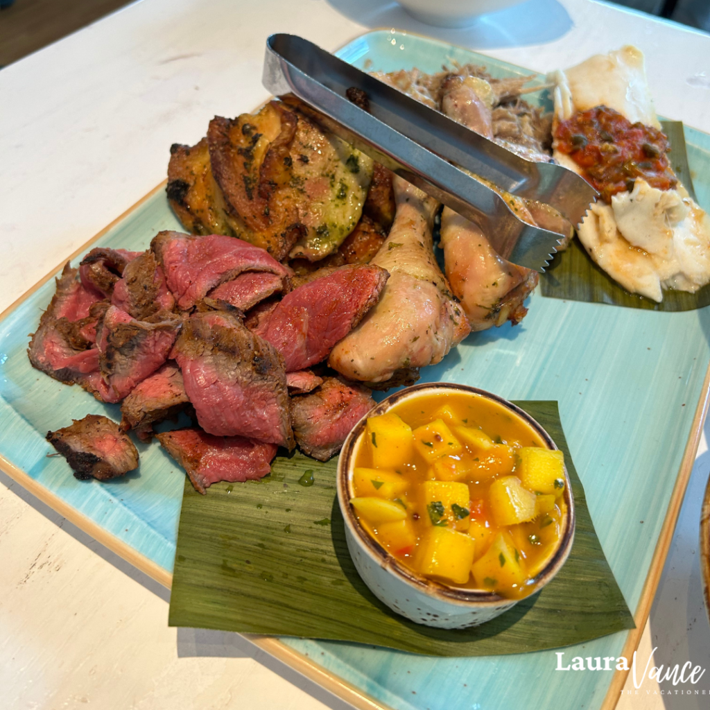 Sebastian's Bistro at Caribbean Beach Resort photo of Oven-roasted Citrus Chicken, Slow-cooked Mojo Pork with Mango Sambal, Grilled Chili-rubbed Beef* with Mojito Relish, and Sustainable Baked Fish with Veracruz Sauce